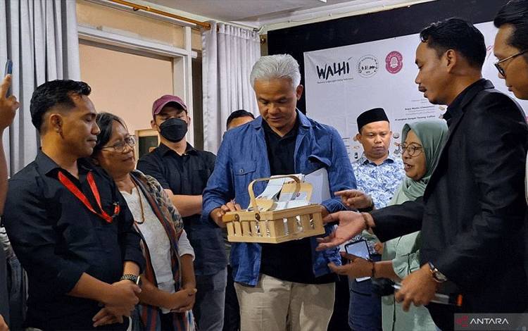 Capres RI Ganjar Pranowo menerima kopi dan rempah hasil bumi Indonesia saat berkunjung ke Kantor WALHI, Jakarta Selatan, Kamis (7/2/2024). ANTARA/Fianda Sjofjan Rassat