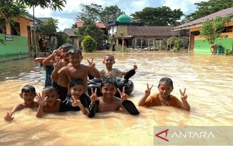 Arsip - Sejumlah anak main air saat banjir di Kelurahan Kupang, Kabupaten Tapin, Kalimantan Selatan, Jumat (3/2/2023). Air banjir yang terkontaminasi kencing tikus bisa menjadi penular penyakit leptospirosis. ANTARA/Muhammad Fauzi Fadilah