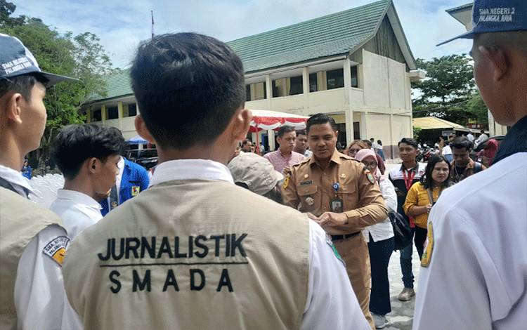 Plt/Kadisdik Provinsi Kalteng M. Reza Prabowo saat bercengkrama dengan siswa Jurnalistik SMAN 2 Palangka Raya (Foto: MARINI)