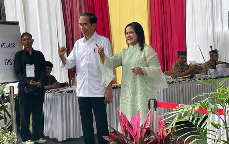 Presiden Joko Widodo dan Ibu Negara Iriana menunjukkan jari kelingking tertanda tinta sebagai bukti telah mencoblod di TPS 10 Gambir, Jakarta Pusat, Jakarta, Rabu (14/2/2024). ANTARA/Yashinta Difa
