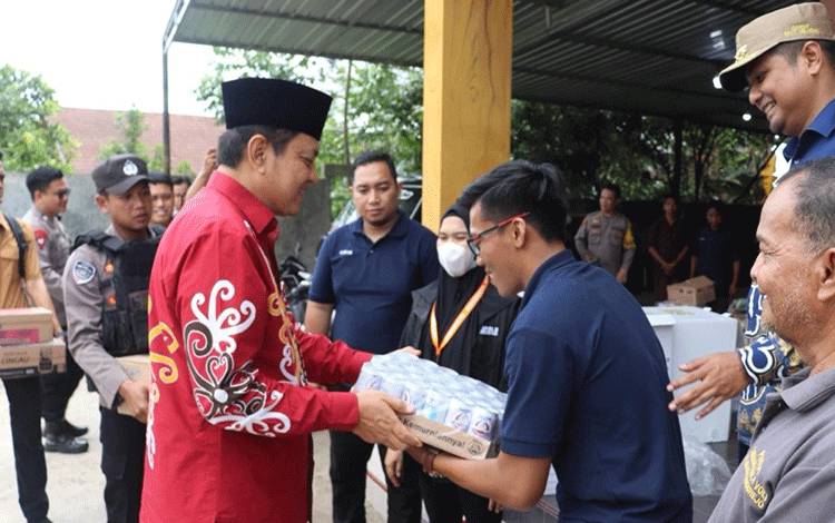 Pj Bupati Kobar Budi Santosa saat menyerahkan minuman suplemen kepada petugas KPPS. (Foto : ISTIMEWA)