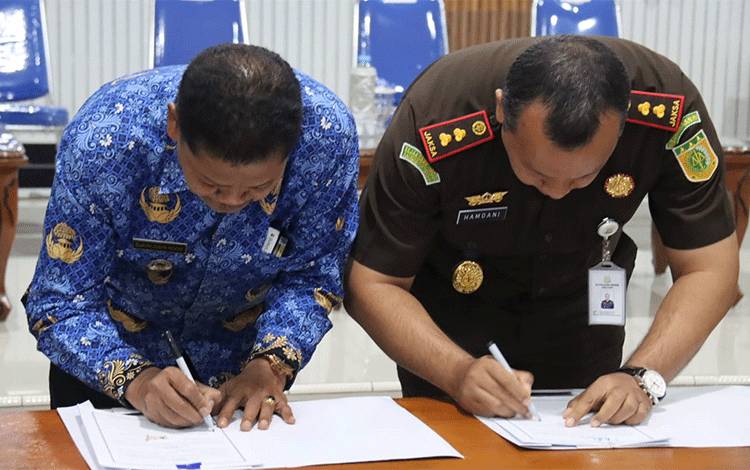 Pj Bupati Seruyan Djainuddin Noor bersama Kepala Kejaksaan Negeri Seruyan Gusti Hamdani tandatangani kesepakatan bersama (FOTO : PROKOM SERUYAN)