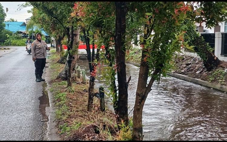 Kapolsek Pahandut Kompol Volvy Apriana saat meninjau kondisi drainase di Jalan Krakatau (Foto :PATHUR)