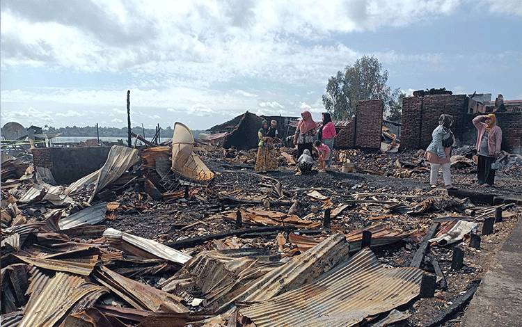 Sejumlah warga melihat puing-puing sisa kebakaran Kompleks Pasar mingguan Maliku Baru, Kecamatan Maliku, Kabupaten Pulang Pisau, Selasa, 27 Februari 2024. (FOTO : M PRADILA KANDI)