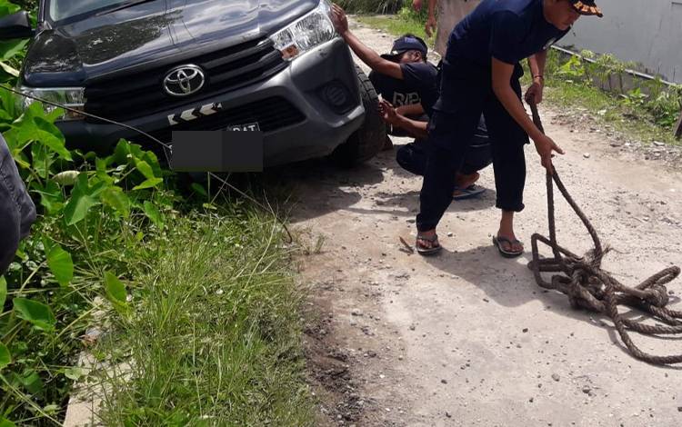 Tim Rescue DPKP Palangka Raya saat membantu mengeluarkan mobil Toyota Hilux dari saluran air. (FOTO: Call Center 112 Palangka Raya)