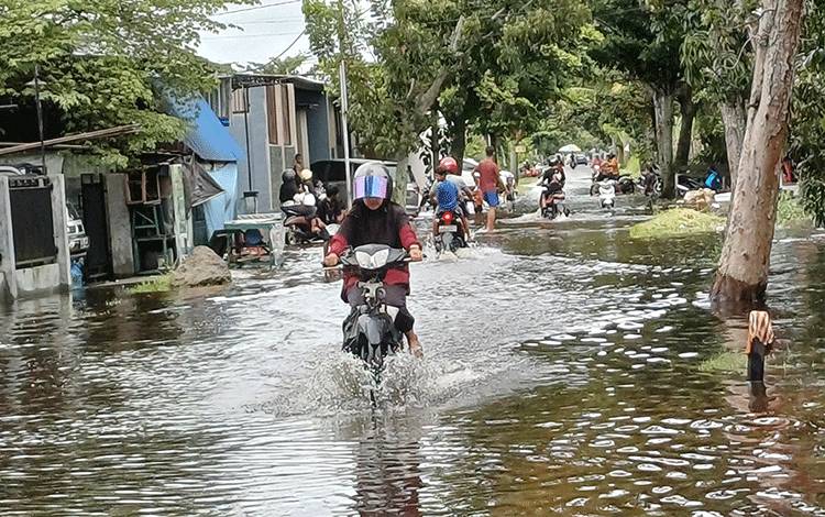 Warga berkendara di tengah genagan air akibat hujan melanda di Jalan Suprapto Selatan Sampit. (FOTO:DEWIP)