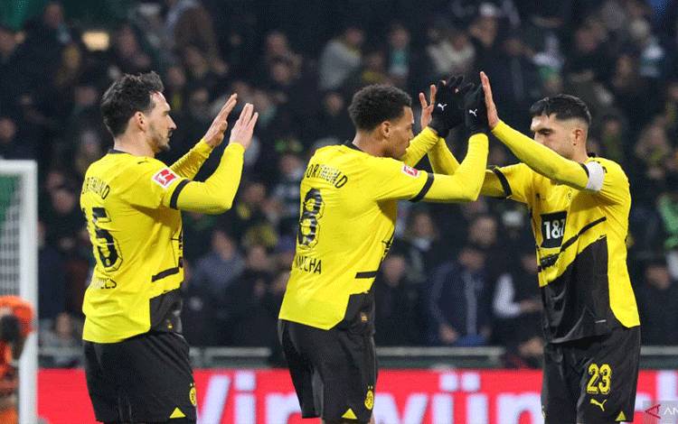 Tiga pemain Borussia Dortmund, Mats Hummels, Felix Nmecha, dan Emre Can (ki-ka) merayakan kemenangan 2-1 atas Werder Bremen pada pertandingan Liga Jerman di Weserstadion, Bremen, Sabtu (9/3/2024). (ANTARA/AFP/FOCKE STRANGMANN)