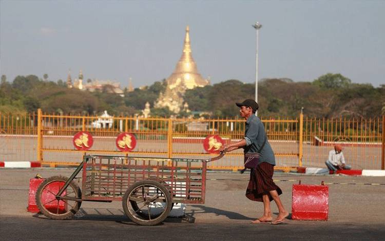 Arsip - Seorang pria mendorong gerobak melewati Lapangan Rakyat di Yangon, Myanmar, 4 Februari 2021. (Xinhua/Zhang Dongqiang)