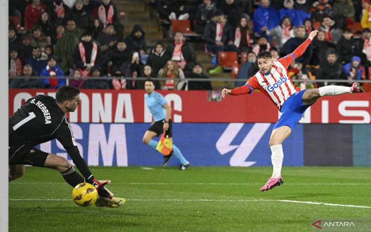 Girona's Spanish forward #24 Cristian Portugues scores the opening goal during the Spanish league football match between Girona FC and CA Osasuna at the Montilivi stadium in Girona on March 9, 2024. (Photo by Josep LAGO / AFP) (AFP/JOSEP LAGO)