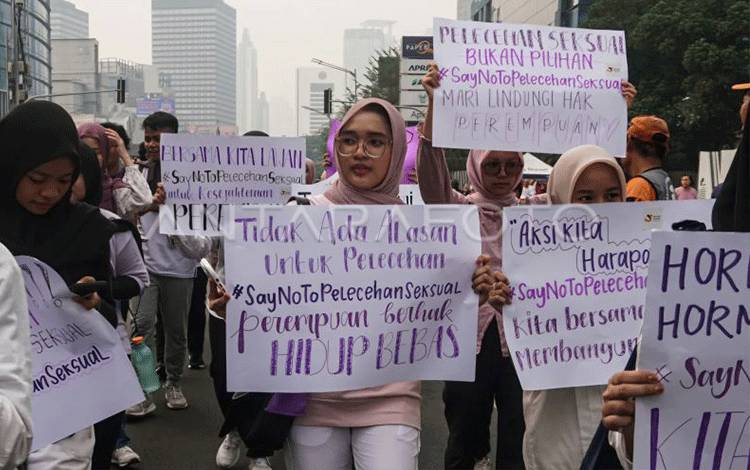 Sejumlah mahasiswa yang tergabung dalam Social Youth Community membawa poster saat sosialisasi pencegahan pelecehan seksual pada Hari Bebas Kendaraan Bermotor (HBKB) di Jalan Jenderal Sudirman, Jakarta, Minggu (24/12/2023). (ANTARA FOTO/Rifqi Raihan Firdaus/tom.)