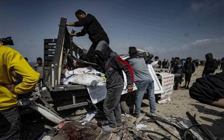 Warga Palestina mengeluarkan puing-puing kendaraan bantuan kemanusiaan yang rusak berat, yang menjadi sasaran serangan udara Israel yang mengakibatkan sembilan orang tewas dan puluhan lainnya luka-luka, di Deir al-Balah, Gaza, Palestina, Minggu (3/3/2024). (ANTARA/ANADOLU)
