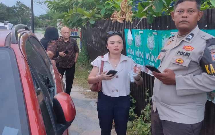 Korban Riri Hawi Anugerahini saat dimintai keterangan oleh piket SPKT Polresta Palangka Raya, di lokasi kejadian mobil pecah kaca Jalan Temanggung Tilung (Foto : PATHUR)