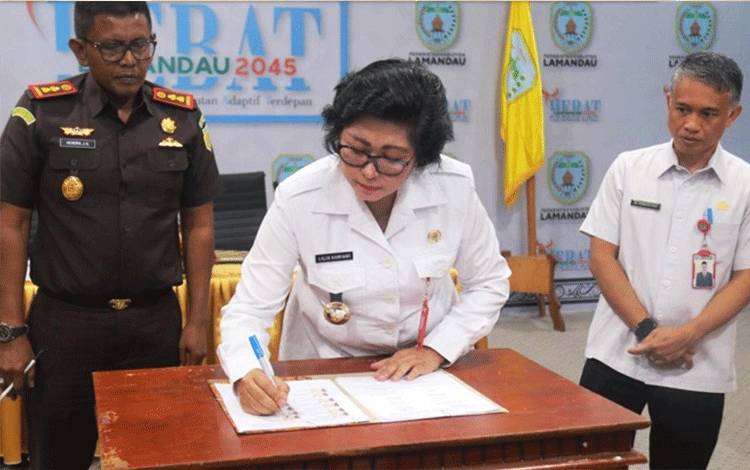 Penjabat Bupati Lamandau Lilis Suriani menandatangani MoU Mall Pelayanan Publik. (FOTO : HENDI NURFALAH)