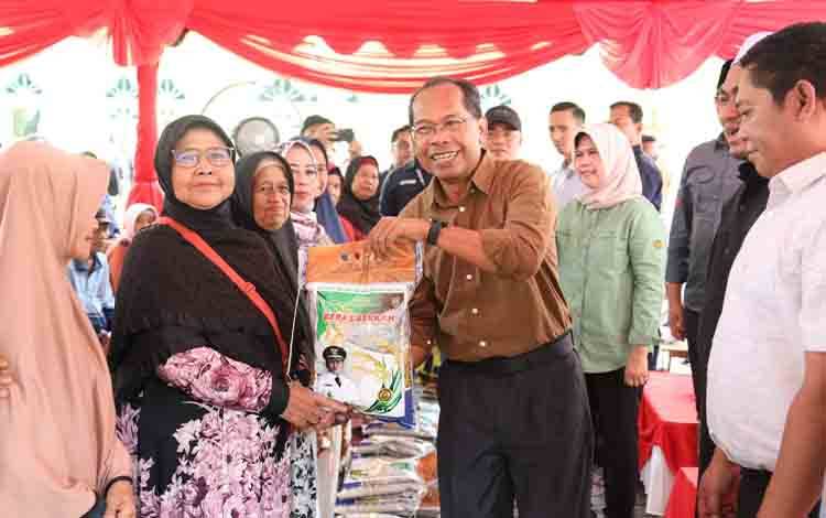 Kepala Dinas Kesehatan Provinsi Kalteng, Suyuti Syamsul bersama Kepala Perangkat Daerah Provinsi Kalteng terkait lainnya saat menyerahkan paket beras kepada masyarakat di Kelurahan Mendawai. (FOTO: FERY)
