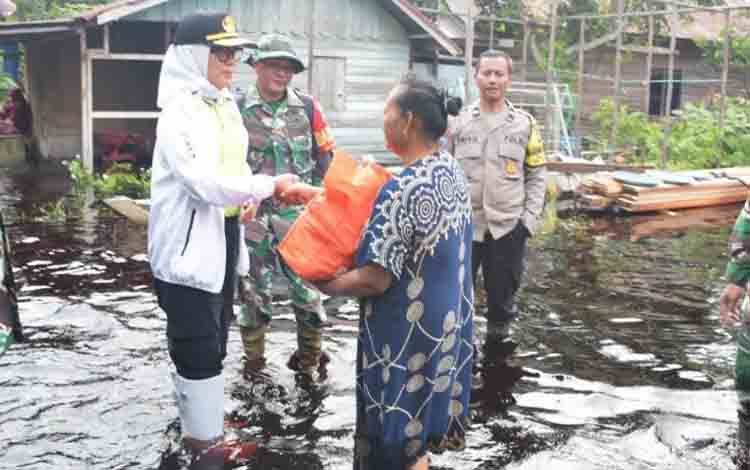 Pj Wali Kota Palangka Raya, Hera Nugrahayu saat menyerahkan bantuan sosial kepada warga terdampak banjir. (FOTO: HUMAS)