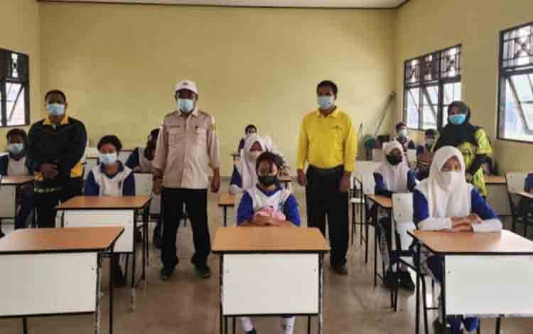Kadisdik Palangka Raya, Jayani membagikan masker kepada pelajar saat bencana kabut asap. (FOTO: IST)