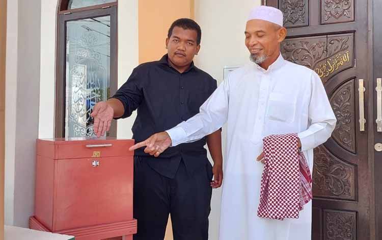 Pengurus Masjid Nurul Ikhwan Mahfud saat menunjukkan kotak amal yang di bongkar (Foto : PATHUR)