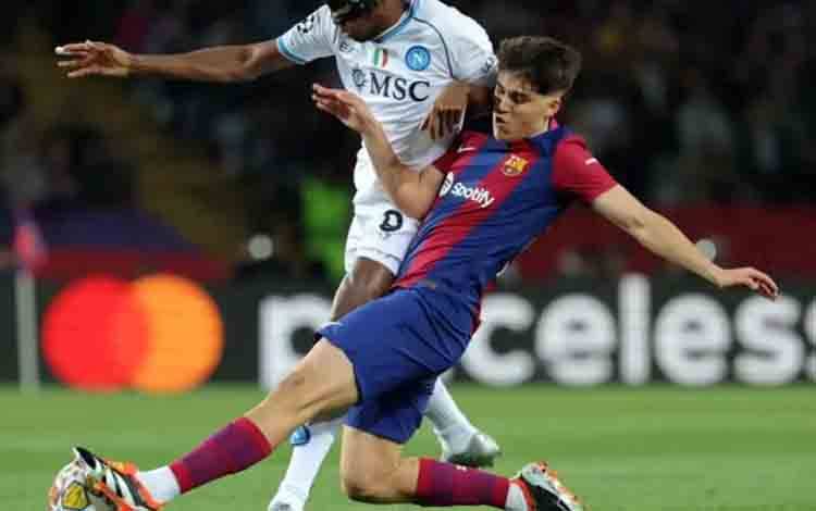 Bek muda Barcelona Pau Cubarsi (kanan) saat menghadang striker Napoli Victor Osimhen. (AFP/LLUIS GENE)