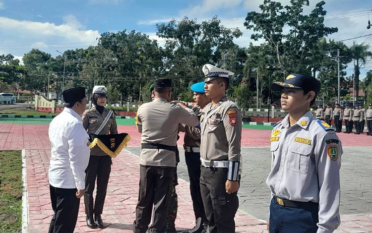 Kapolres Sukamara, AKBP Telly Alvin memasang pita tanda dimulainya Operasi Ketupat Telabang 2024 kepada personil. Rabu, 3 April 2024.  (FOTO : NORHASANAH)