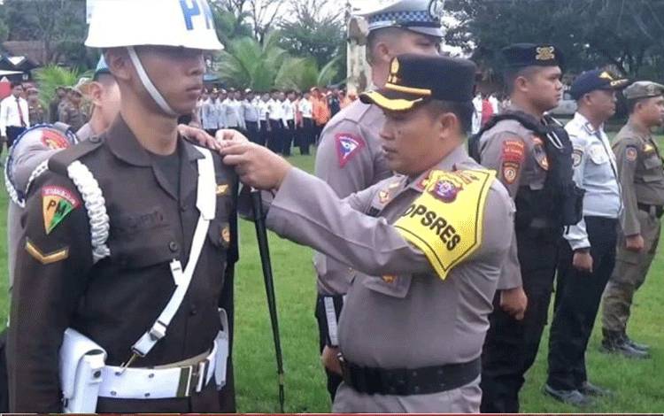 Kapolres Kotim AKBP Sarpani memasangkan pita pada perwakilan anggota pasukan Operasi Kepolisian Terpusat Ketupat Telabang 2024, Rabu (3/4/2024). ANTARA