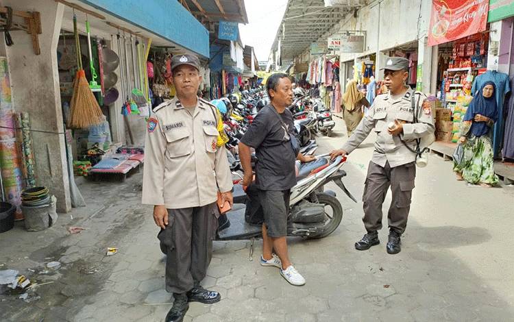 Anggota Unit Binmas Polsek Pahandut Aiptu Edi dan Aipda Sumardi saat menyampaikan pesan Kamtimbas di pasar besar Palangka Raya (Foto : Polsek Pahandut)