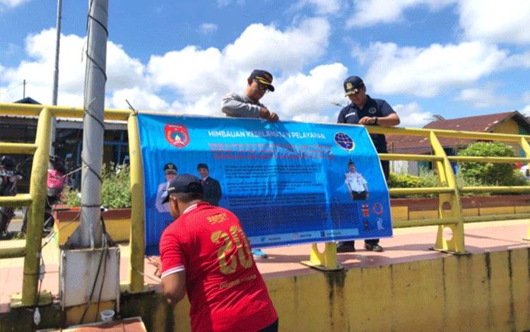 Petugas Dishub Kobar memasang spanduk imbauan keselamatan transportasi sungai, di Water Front City. (Foto : DISHUB KOBAR)