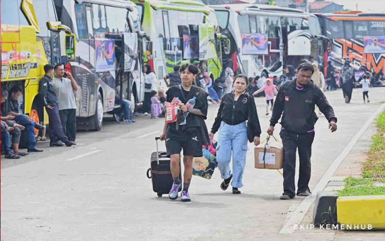 Calon penumbang berjalan sambil membawa barang dalam program mudik gratis dengan bus di Terminal Jatijajar, Depok, Jawa Barat, di Depok, Sabtu (6/4/2024). ANTARA/HO-Humas Kemenhub