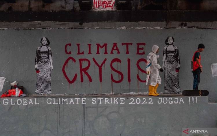 Ilustrasi - Dua aktivis dari Fossil Free Jogja melakukan aksi Global Climate Strike (GCS) dengan menggambar mural di Jembatan Kewek, Yogyakarta, Jumat (23/9/2022). Aksi yang mengkritisi persoalan krisis iklim dan dampaknya tersebut mengusung tema Stop Bencana Iklim. (ANTARA FOTO/Hendra Nurdiyansyah/foc.)