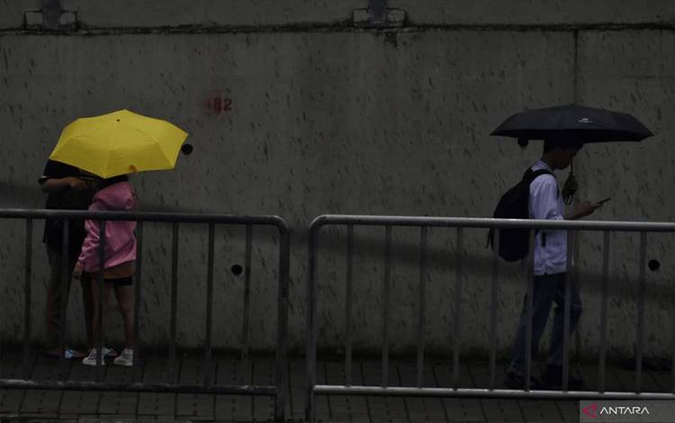 Arsip- Pejalan kaki menggunakan payung untuk berlindung dari hujan saat melintas di pedestrian MRT Lebak Bulus, Jakarta (ANTARA FOTO/M RIEZKO BIMA ELKO PRASETYO)