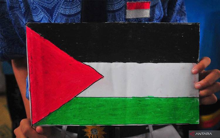 Siswa memegang poster bendera Palestina saat mengikuti aksi solidaritas untuk Palestina di SMP Muhammadiyah 1 Kudus, Kudus, Jawa Tengah, Selasa (24/10/2023).. ANTARA FOTO/Yusuf Nugroho/Spt. (ANTARA FOTO/YUSUF NUGROHO)