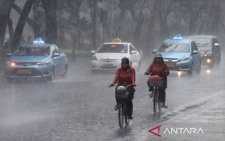 Dua orang pesepeda menembus hujan lebat di Jalan Merdeka Selatan, Jakarta. (ANTARA FOTO/Wahyu Putro A/foc/aa.)