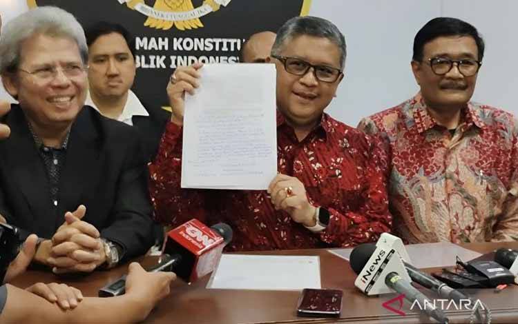 Sekjen PDI Perjuangan Hasto Kristiyanto (tengah) menunjukkan tulisan tangan Megawati dalam surat Amicus Curiae yang disampaikan oleh Megawati Soekarnoputri di Gedung II Mahkamah Konstitusi, Jakarta, Selasa (16/4/2024). ANTARA/Nadia Putri Rahmani