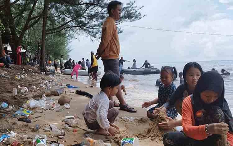 Anak-anak bermain di tengah sampah di Pantai Ujung Pandaran. (FOTO: IST)
