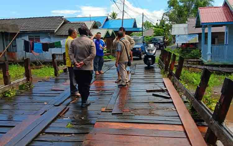 Camat Bataguh, Syuryadin saat mengecek perbaikan jembatan di Desa Pulau Mambulau. (FOTO: IST)