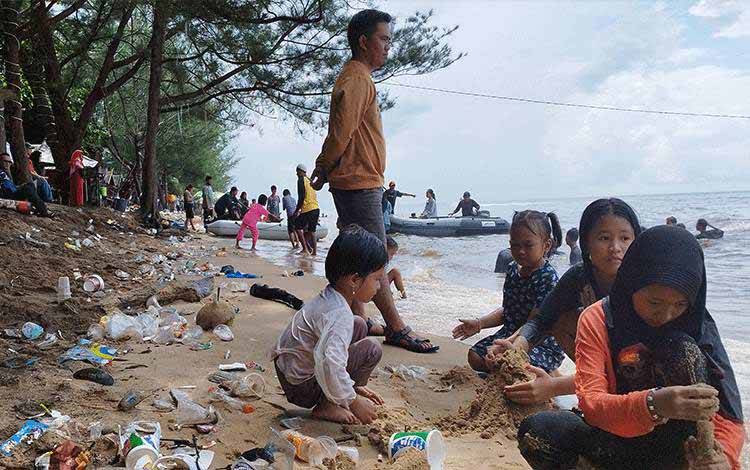 Anak-anak bermain di tengah sampah di Pantai Ujung Pandaran. (FOTO: IST)