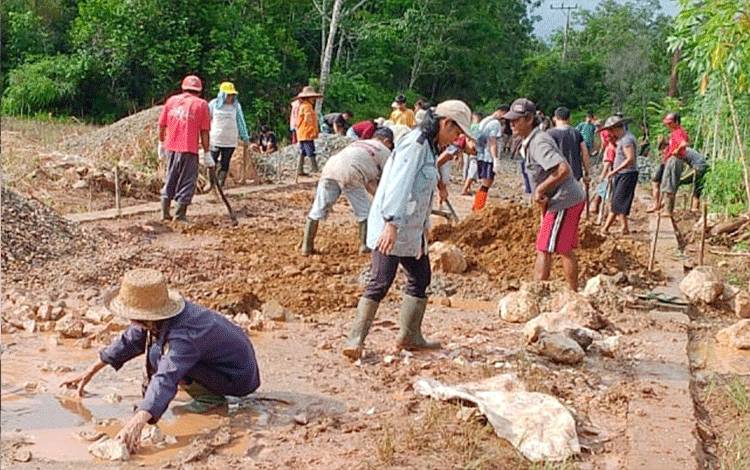 Warga Desa Janah Jari Kabupaten Barito Timur turut bekerja dalam pembangunan siring timbun jalan penghubung menuju Kota Tamiang Layang, Kamis, 18 April 2024. (FOTO: BOLE MALO)