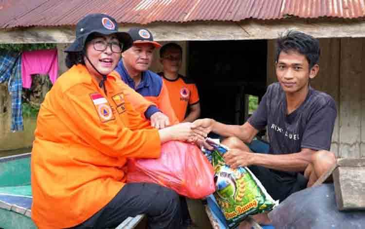 Penjabat Bupati Lamandau Lilis Suriani salurkan bantuan kepada warga terdampak banjir. (FOTO: HENDI NURFALAH)