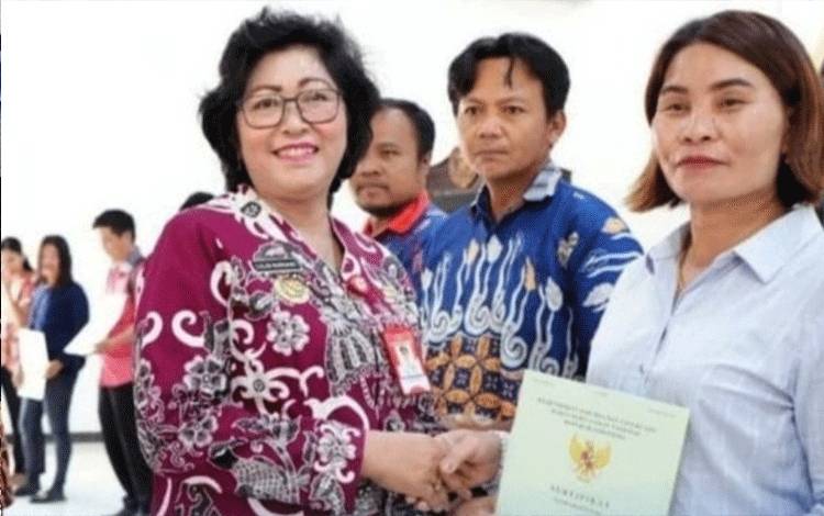 Secara simbolis Penjabat Bupati Lamandau Lilis Suriani menyerahkan sertifikat program PTSL kepada salah satu warga. (FOTO : HENDI NURFALAH)