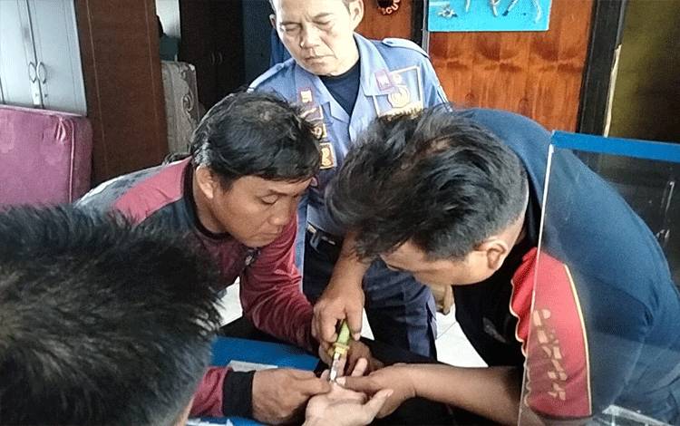 Tim Damkarmat Palangka Raya saat berupaya melepaskan cincin Samsul disaksikan Kepala Seksi Pengendali Operasi Komunikasi Penyelamatan Sucipto (Foto : IST)