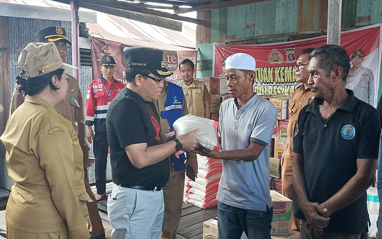 Pj Bupati Kapuas, Erlin Hardi saat serahkan bantuan kepada warga terdampak musibah kebakaran rumah. (FOTO: DODI)