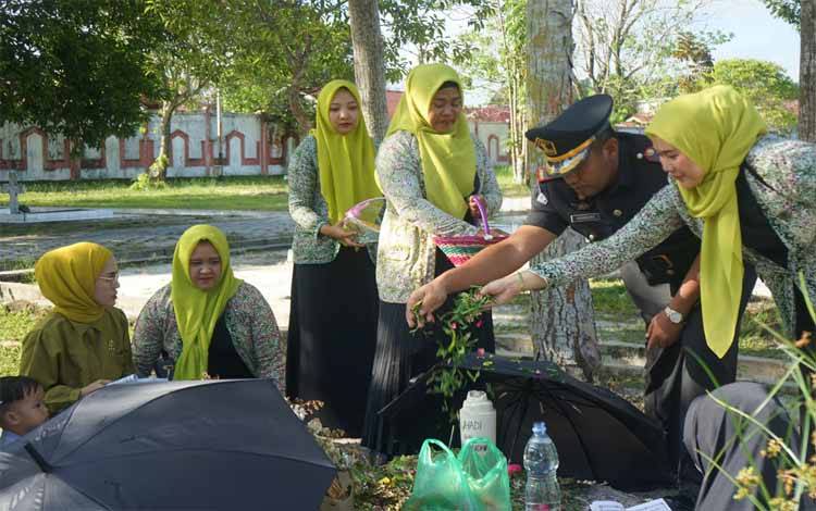 Kepala Rutan Kelas IIA Palangka Raya Bambang Widiyanto didampingi Ketua DWP Rutan Palangka Raya Sisca Nurdayanti Widianto saat melakukan tabur bunga di TMP Sanaman Lampang (Foto : PATHUR)