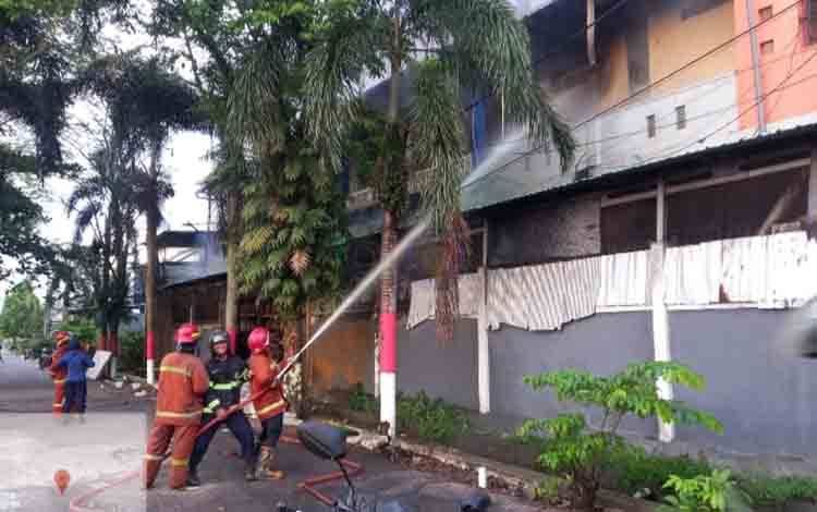 Petugas Disdamkarmat Kotim melakukan pemadaman api di lokasi kebakaran toko bahan bangunan di Jalan MT. Haryono Barat, Sampit, Kabupaten Kotawaringin Timur (Kotim). (FOTO: BUDDI)