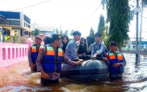 Polres Barito Utara Bantu Anak Sekolah Lintasi Banjir dengan Perahu Karet